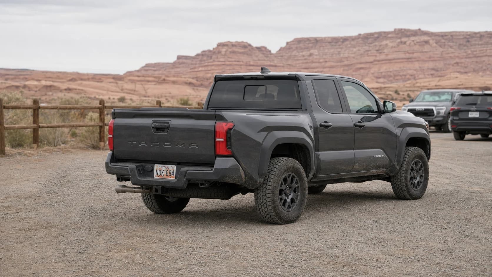 Charcoal fourth-generation Toyota Tacoma parked on 33-inch-class all-terrain tires at a Utah trailhead