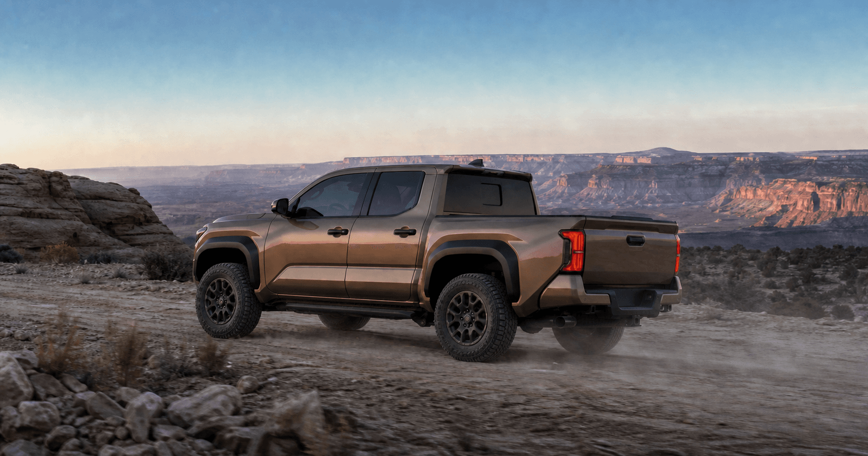 Bronze fourth-generation Toyota Tacoma on 33-inch all-terrain tires above a Utah canyon