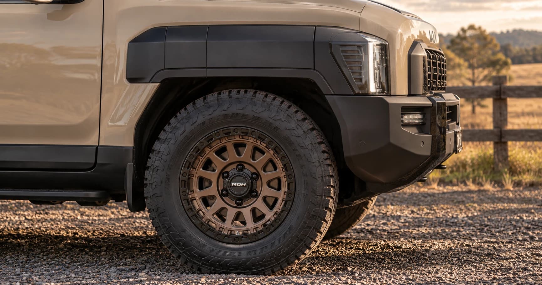 Front-wheel detail of a 2025 Kia Tasman X-Line 4x4 double cab with ROH Assault wheels in Bronze Centre Black Lip