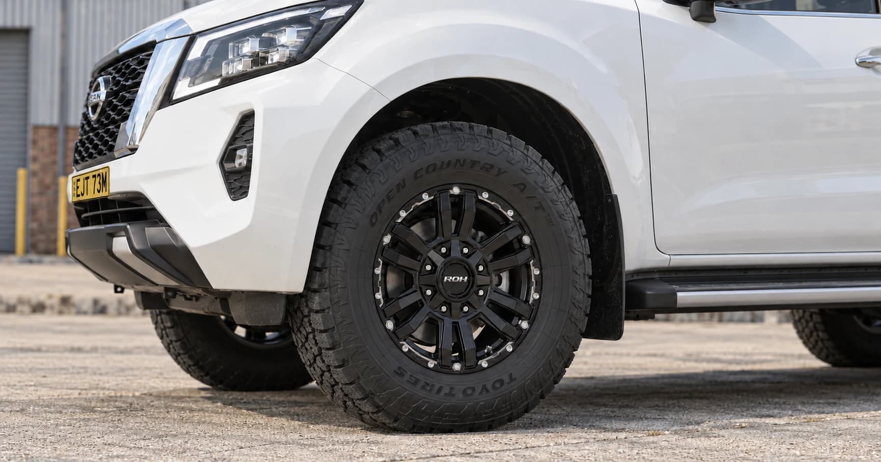 Front-wheel detail of a 2024 Nissan Navara ST 4x4 dual cab with ROH Vapour wheels in Matte Black Machined Accents