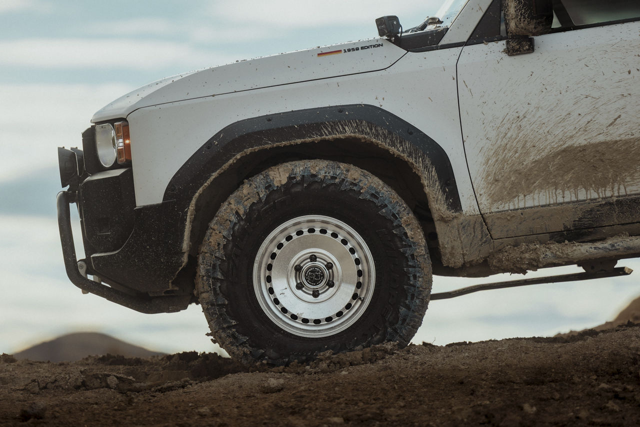 White 4x4 wagon on its original wheels and mud-terrain tyres
